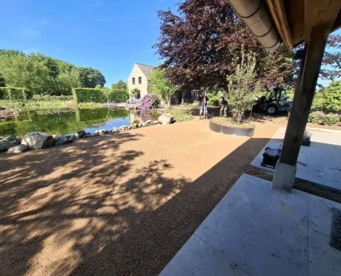 Halfverharding aangelegd als wandelpad langs vijver bij woning